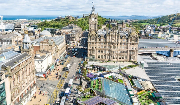 Aerial view of Waverley city center with an ornate brick building, tram lines, and a waterfront in the distance.